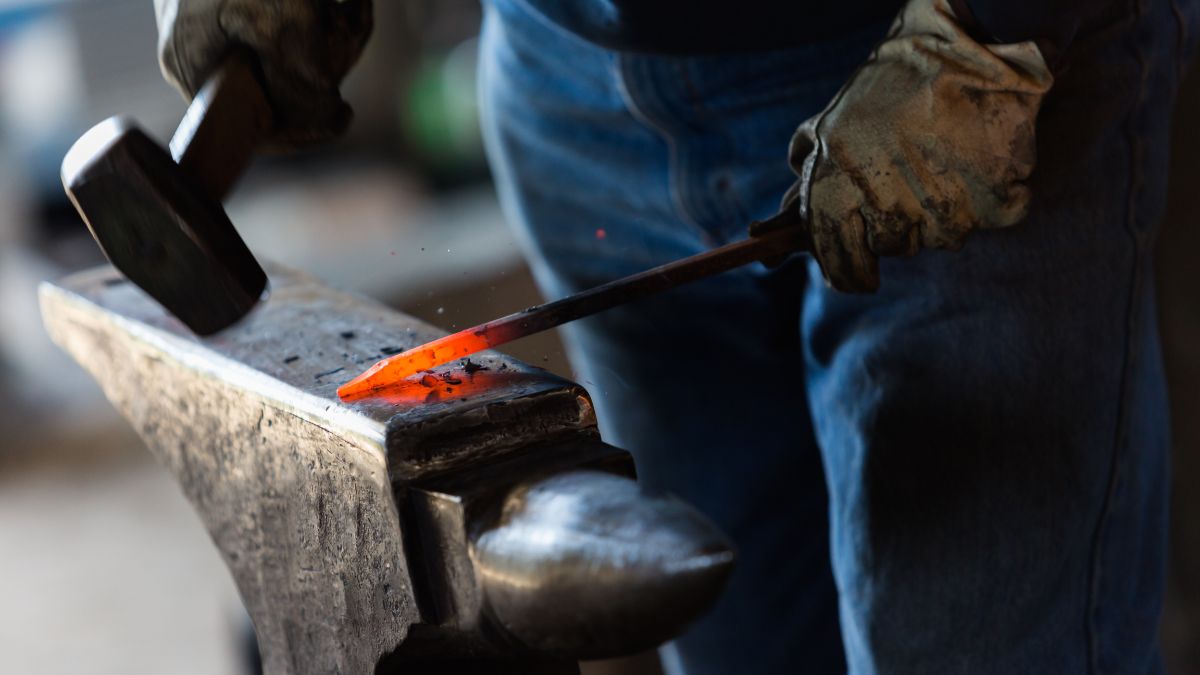 Blacksmith striking glowing orange metal