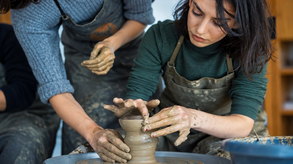 shaping a clay vase on a pottery wheel