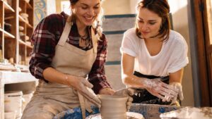 Women working on potters wheel making clay objects