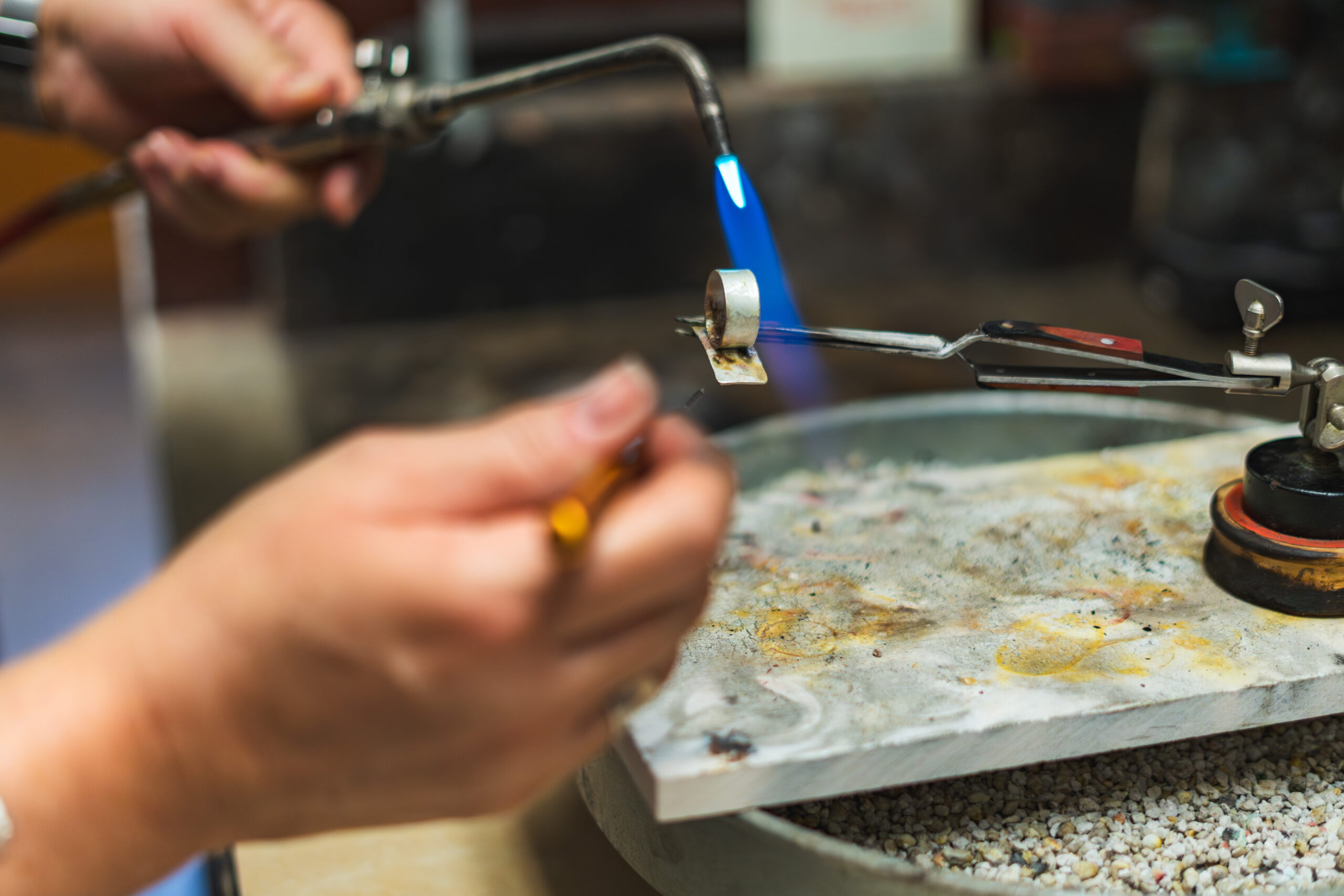 A student soldering a ring in the jewelry studio of the Brookfield Craft Cener.