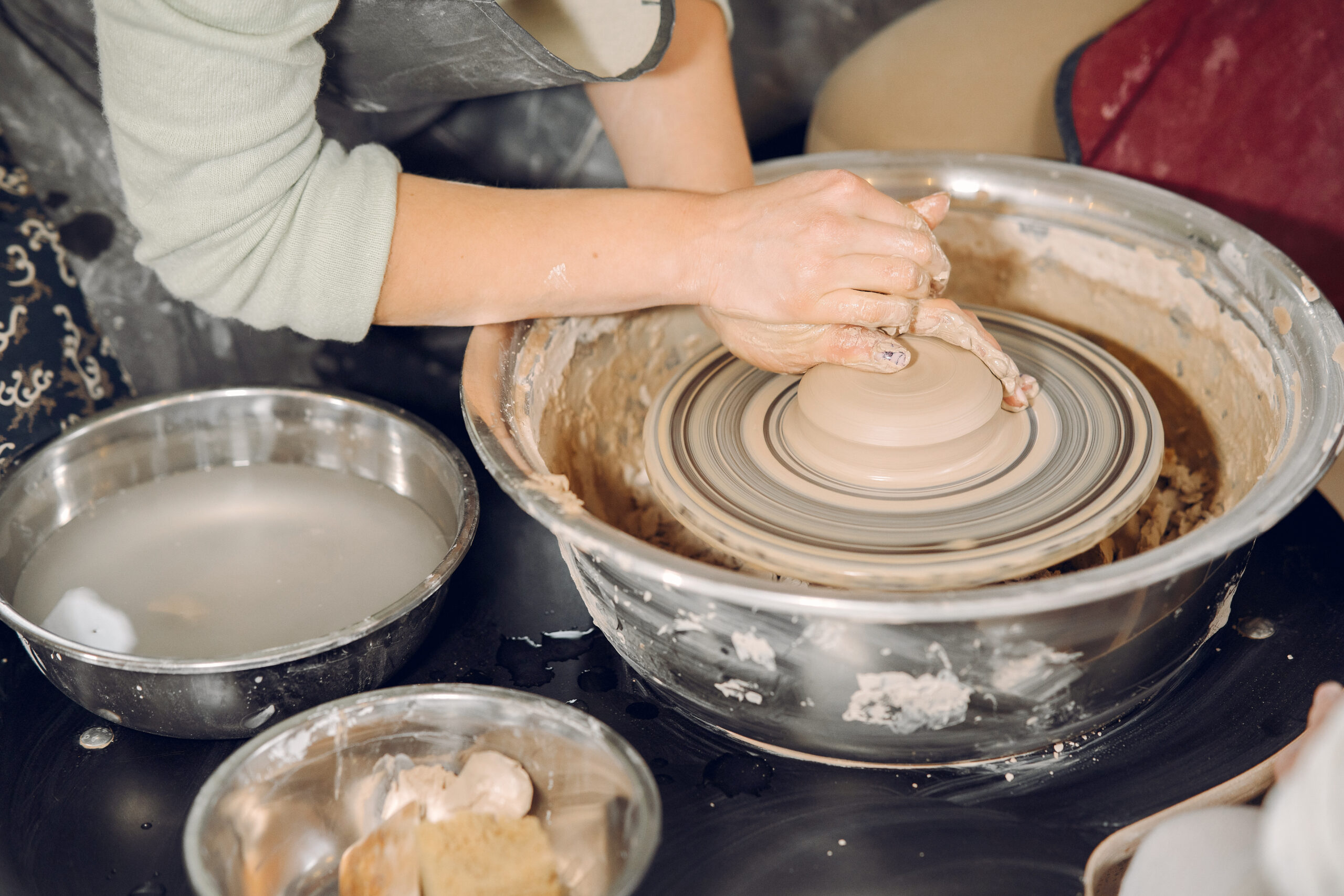 an artisan's clay-covered hands