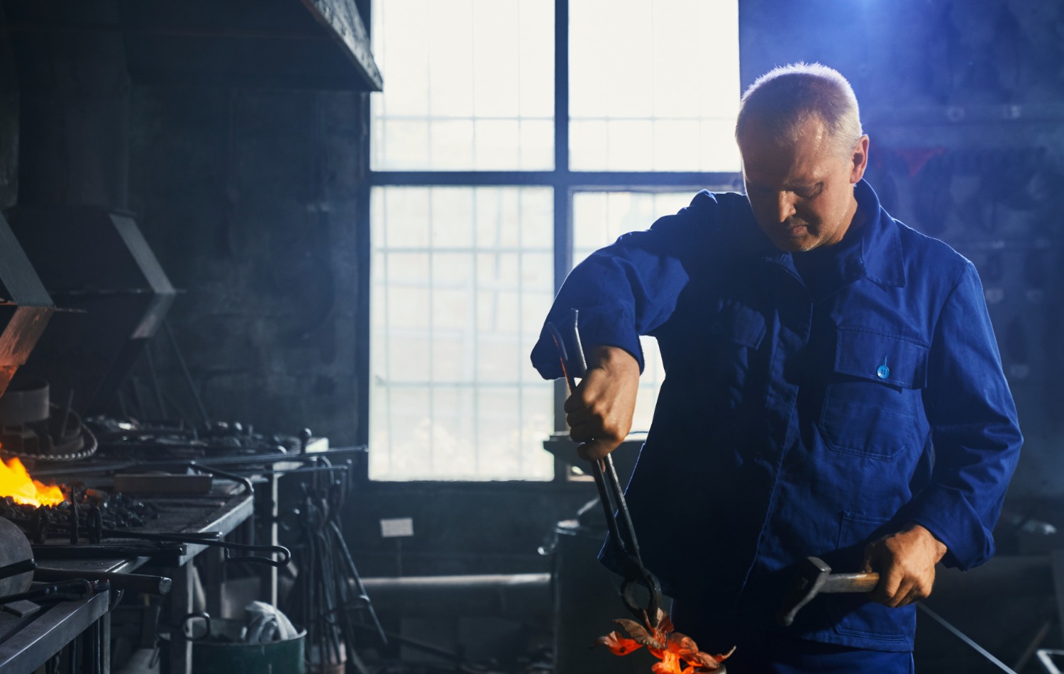 man in dark blue uniform working with hammer plier