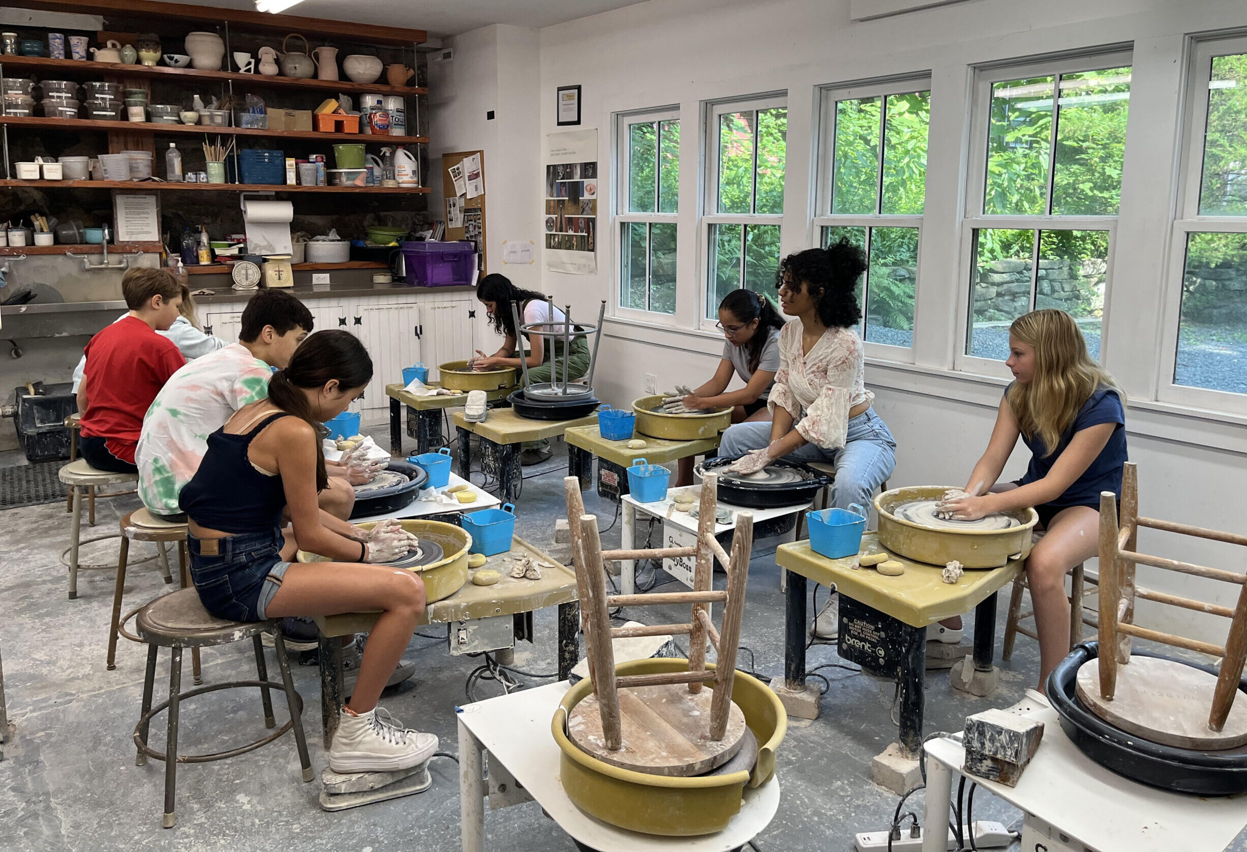 children work on the pottery wheels at the Brookfield Craft Center.